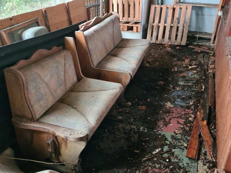Alte Sofas und Paletten in einem verwitterten Anbau